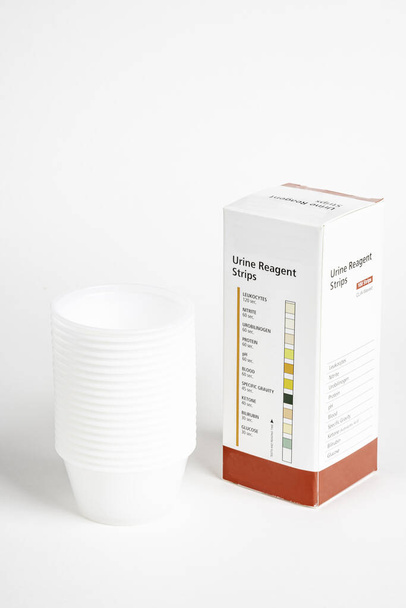 Urine Strips Box en een stapel plastic containers - Foto, afbeelding