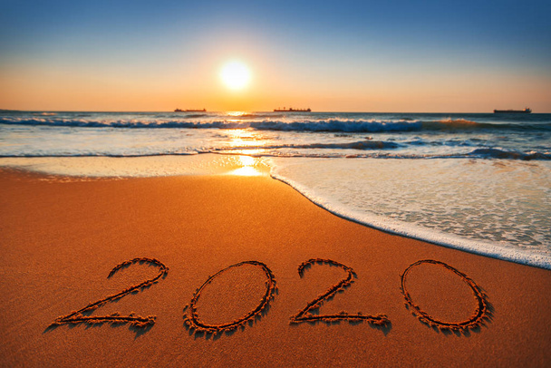 Feliz Año Nuevo 2020 concepto, letras en la playa. Salida del sol del mar
 - Foto, imagen