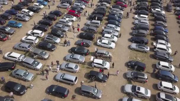 Park etmiş birçok arabanın ve araba pazarında veya otoparkta yürüyen müşterilerin hava manzarası.. - Video, Çekim
