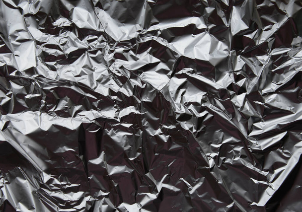 Crumpled silver aluminum foil closeup background texture. Abstract metallic paper holographic pattern - Photo, Image