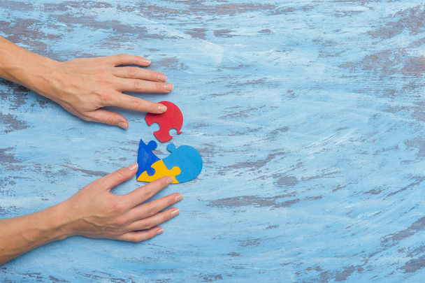 Kézfogás Színes Szív Kék Háttér. Az autizmus tudatosságának világnapja koncepció - Fotó, kép