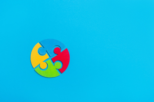 Peça de quebra-cabeças coloridos sobre fundo azul. Conceito do Dia Mundial da Consciência do Autismo
 - Foto, Imagem