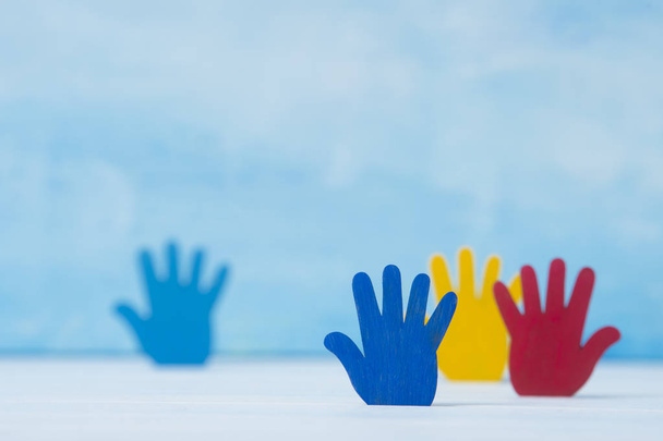 Farbenfrohe Rätsel Hände auf blauem Hintergrund. Konzept zum Welt-Autismus-Tag - Foto, Bild