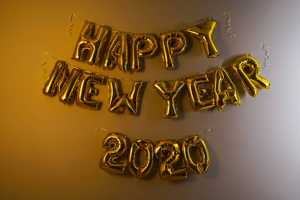 Празднование Нового 2020 года. Шарики из золотой фольги на сером фоне. Фольга
 - Фото, изображение
