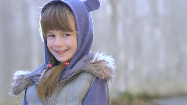 Portrait of happy child girl in warm clothes in autumn outdoors. - Footage, Video