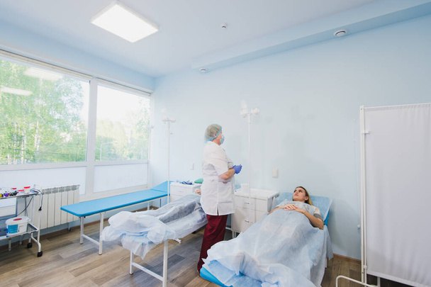 Медсестра, що з'єднує внутрішньовенну краплю в лікарняній кімнаті
. - Фото, зображення