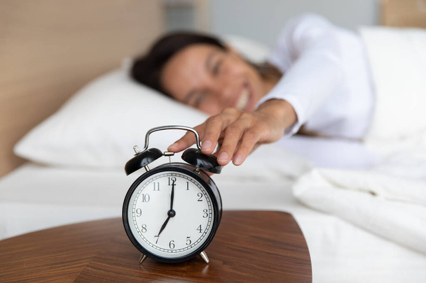Vrouw wakker op zeven oclock schakelt alarm - Foto, afbeelding