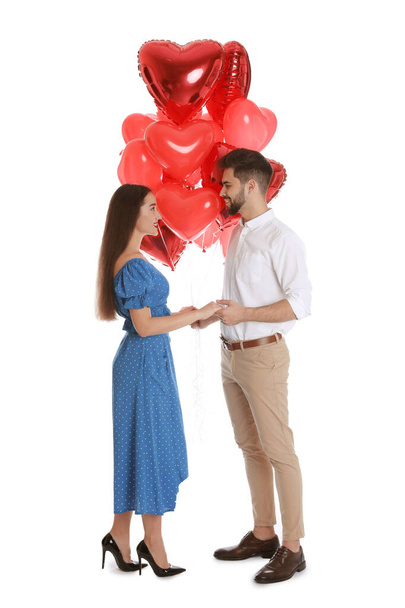 Happy young couple with heart shaped balloons isolated on white. Valentine's day celebration - Fotografie, Obrázek
