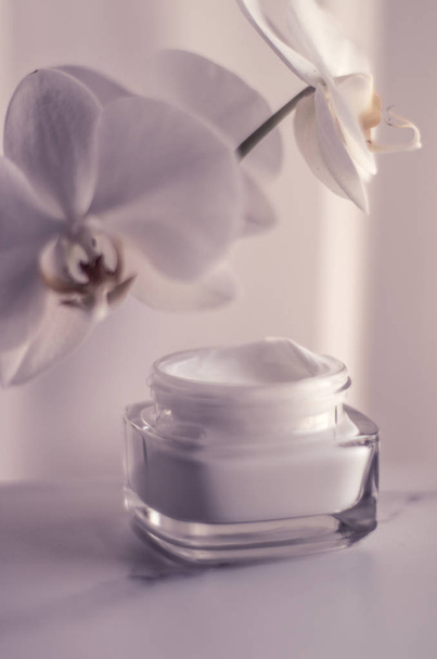 Crème hydratante pour le visage pot et fleur d'orchidée, peau hydratante
  - Photo, image