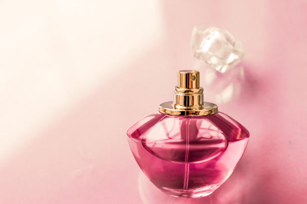 Μπουκαλάκι αρωμάτων ροζ σε γυαλιστερό φόντο, γλυκό λουλουδάτο άρωμα, gl - Φωτογραφία, εικόνα