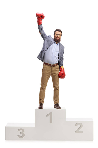 Man with boxing gloves standing on a winners pedestal - 写真・画像