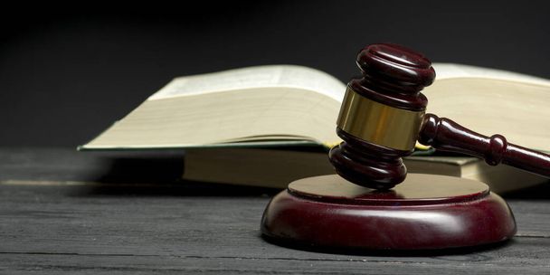 Law concept - Open wet boek met een houten rechters hamer op tafel in een rechtszaal of rechtshandhavingskantoor geïsoleerd op witte achtergrond. Kopieer ruimte voor tekst - Foto, afbeelding