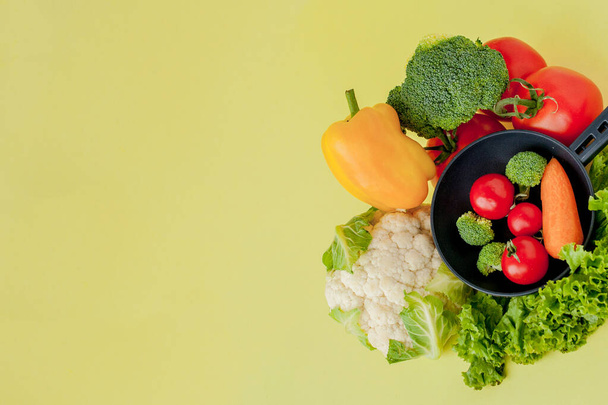 Variety of vegetables and frying pan on a blackboard, top view.  - 写真・画像