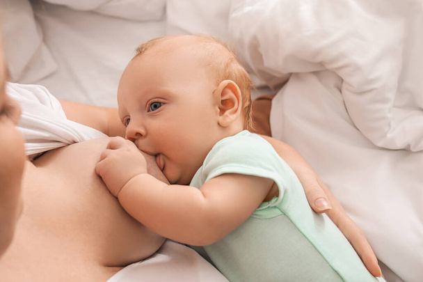 Mujer joven amamantando a su bebé en casa, primer plano - Foto, Imagen