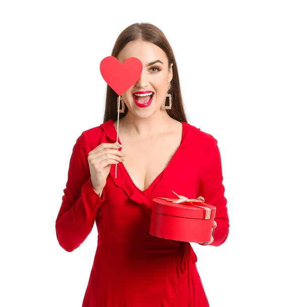 白い背景に赤いハートと贈り物を持つ美しい若い女性。バレンタインデーのお祝い - 写真・画像