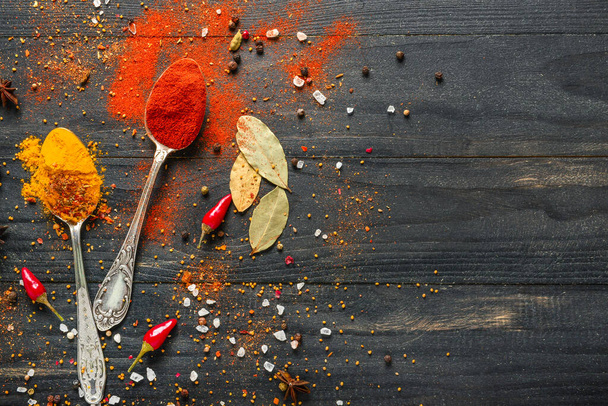 Many different spices on dark wooden background - Photo, image