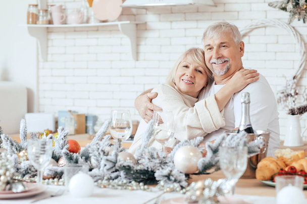 Gelukkig volwassen paar op kerstavond in de keuken - Foto, afbeelding