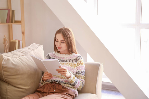 Piękna młoda kobieta czyta książkę w domu - Zdjęcie, obraz