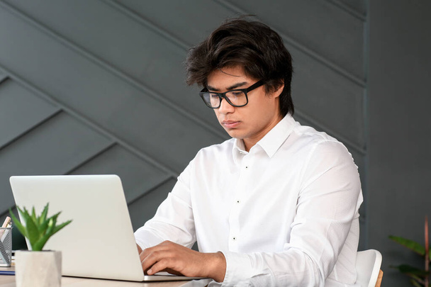 Programador asiático trabajando en el ordenador portátil en la oficina
 - Foto, Imagen