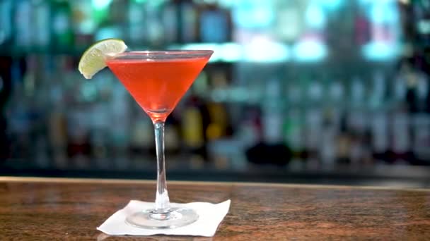 Rood drankje in martini glas op bar counter, close-up van Cosmopolitan cocktail - Video