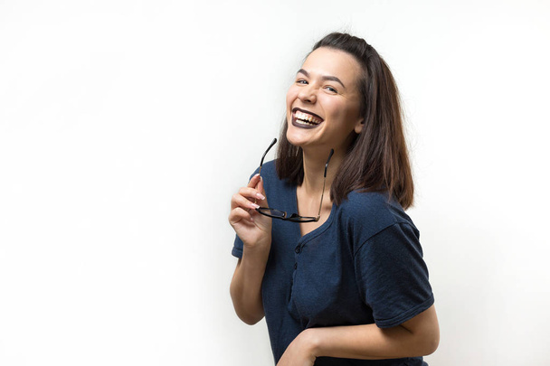 romantisches Mädchen in trendiger Brille posiert mit schüchternem Lächeln. Studio Nahaufnahme Porträt auf weißem Hintergrund. - Foto, Bild