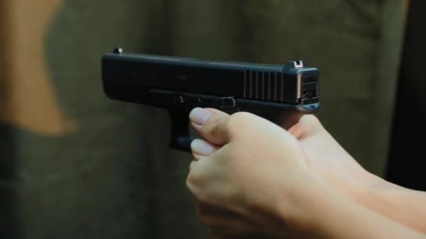 Manos femeninas sosteniendo pistolas dispara al blanco, primer plano
 - Metraje, vídeo
