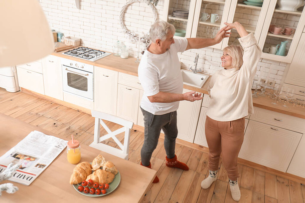 Счастливая зрелая пара танцует на кухне
 - Фото, изображение