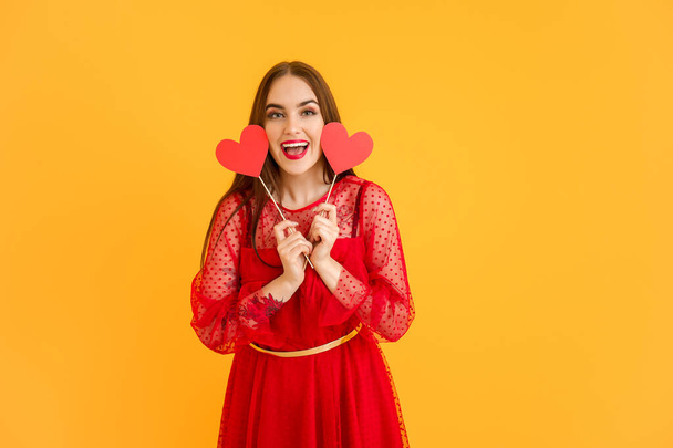 schöne junge Frau mit roten Herzen auf farbigem Hintergrund. Valentinstag-Feier - Foto, Bild