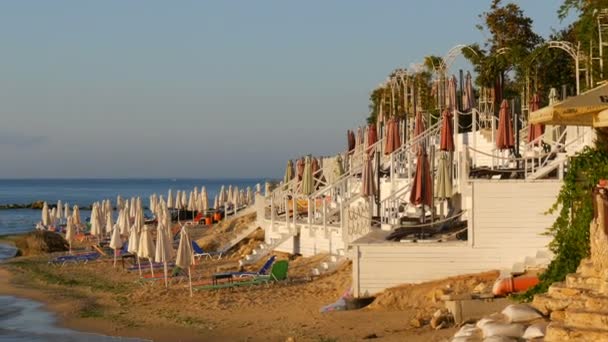 Vacaciones de lujo en el Mar Negro, Bulgaria. Tumbonas vacías multicolores o tumbonas y sombrillas plegadas en la playa del resort
 - Imágenes, Vídeo
