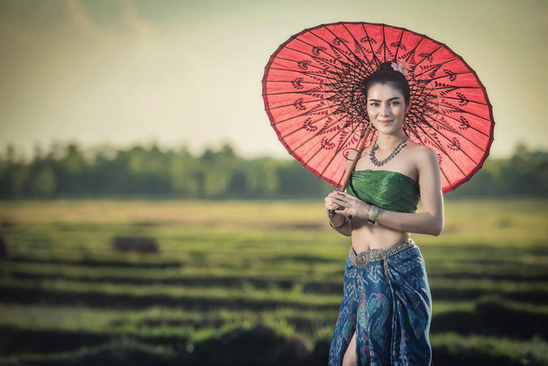 Beautiful woman in traditional dress costume, Asian woman wearing typical Thai dress identity culture of Thailan - Photo, Image