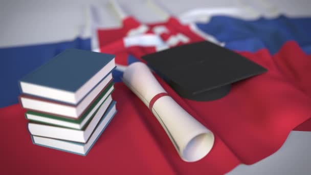 Mütze, Bücher und Diplom auf der slowakischen Flagge. Hochschulbildung in der Slowakei im Zusammenhang mit konzeptioneller 3D-Animation - Filmmaterial, Video