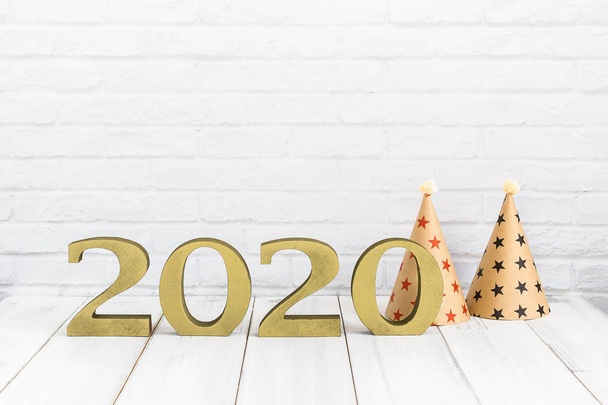 2020 año nuevo y sombrero de fiesta en la mesa de madera blanca sobre respaldo blanco
 - Foto, imagen