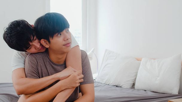 Ázsiai meleg pár csókolózik otthon az ágyon. Fiatal ázsiai Lgbtq + férfiak boldog pihenés együtt töltenek romantikus időt ébredés után a hálószobában otthon a reggeli koncepció. - Fotó, kép