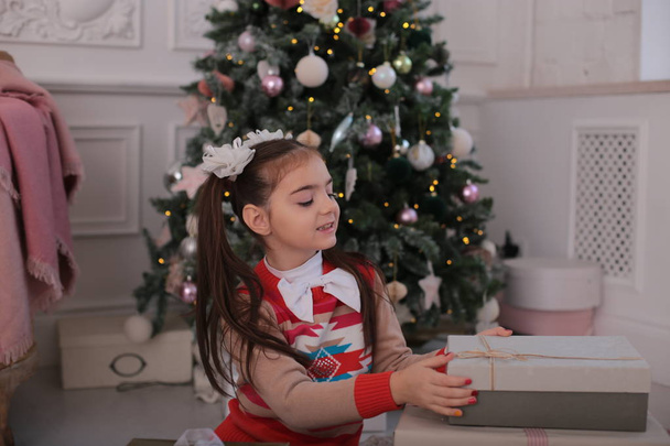 Verspieltes Mädchen feiert Weihnachten und Fratzen am Neujahrsbaum - Foto, Bild