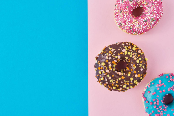 Pastel pembe ve mavi arka planda donutlar. Minimalizm yaratıcı yemek kompozisyonu. Düzleştirme biçimi - Fotoğraf, Görsel