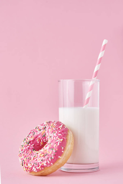 Donuts con vaso de leche sobre fondo rosa
 - Foto, imagen