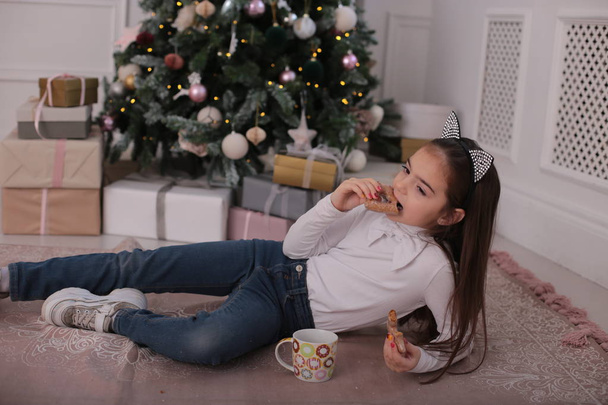 Χριστουγεννιάτικο πορτρέτο ενός όμορφου κοριτσιού με μακριά ξανθά μαλλιά σε παιχνιδιάρικη διάθεση απεικονίζει διαφορετικά συναισθήματα - Φωτογραφία, εικόνα