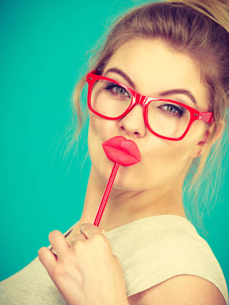 Happy woman holding fake lips on stick - Foto, Bild