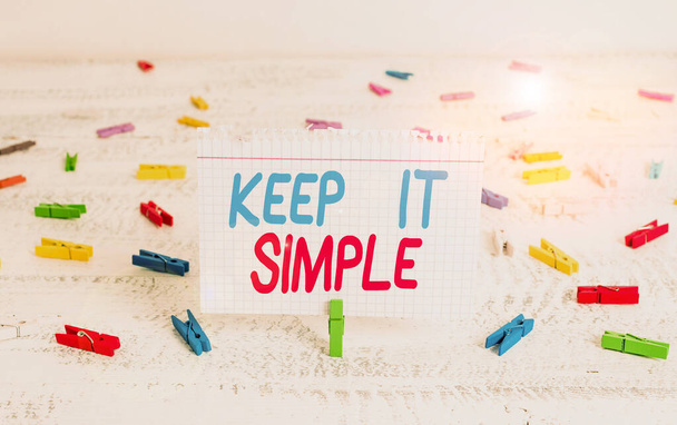 Handwriting text writing Keep It Simple. Concept meaning Remain in the simple place or position not complicated Green clothespin white wood background colored paper reminder office supply. - Photo, Image