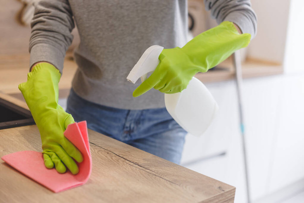 Close up woman cleaning kitchen using cleanser spray and cloth. - Foto, afbeelding