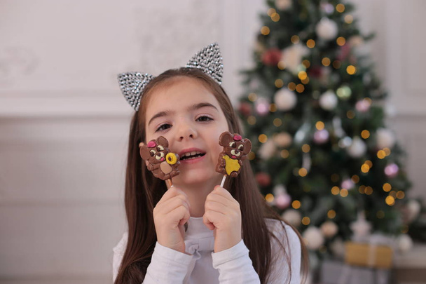 Retrato de Navidad de una hermosa chica con el pelo largo y rubio en un estado de ánimo juguetón representa diferentes emociones
 - Foto, imagen