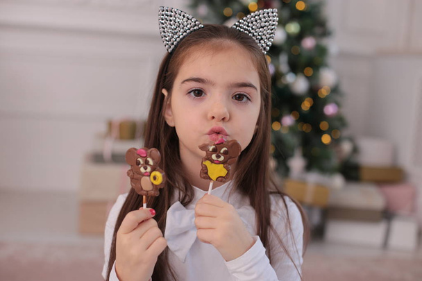 Χριστουγεννιάτικο πορτρέτο ενός όμορφου κοριτσιού με μακριά ξανθά μαλλιά σε παιχνιδιάρικη διάθεση απεικονίζει διαφορετικά συναισθήματα - Φωτογραφία, εικόνα