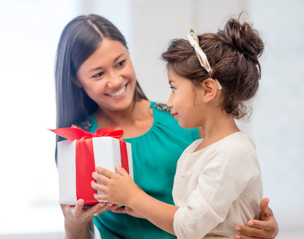 Happy mother and child girl with gift box - 写真・画像