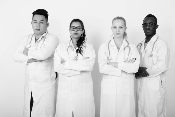 Studio záběr různorodé skupiny multi etnické lékařů, kteří s rukama zkříženýma dohromady - Fotografie, Obrázek