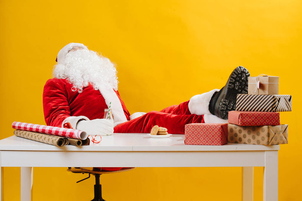 Santa Claus also needs an ocasional break. He's working at the desk. - Foto, Imagen
