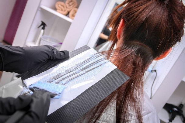 Meisje in de schoonheidssalon, terwijl een kapper die haar haren verven - Foto, afbeelding