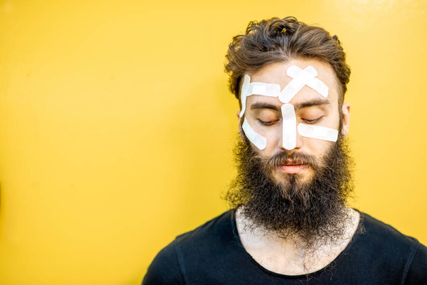 Man with medical patches on his face - Φωτογραφία, εικόνα