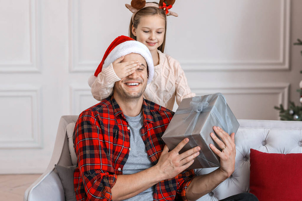 Little girl giving Christmas present to her father at home - Photo, Image