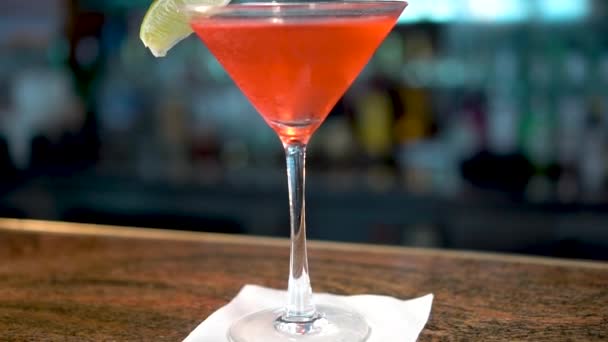 Bebida vermelha em vidro martini no balcão do bar, close-up do coquetel Cosmopolitan
 - Filmagem, Vídeo
