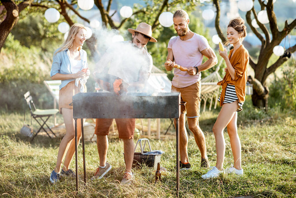 Amis ayant barbecue dans le jardin
 - Photo, image